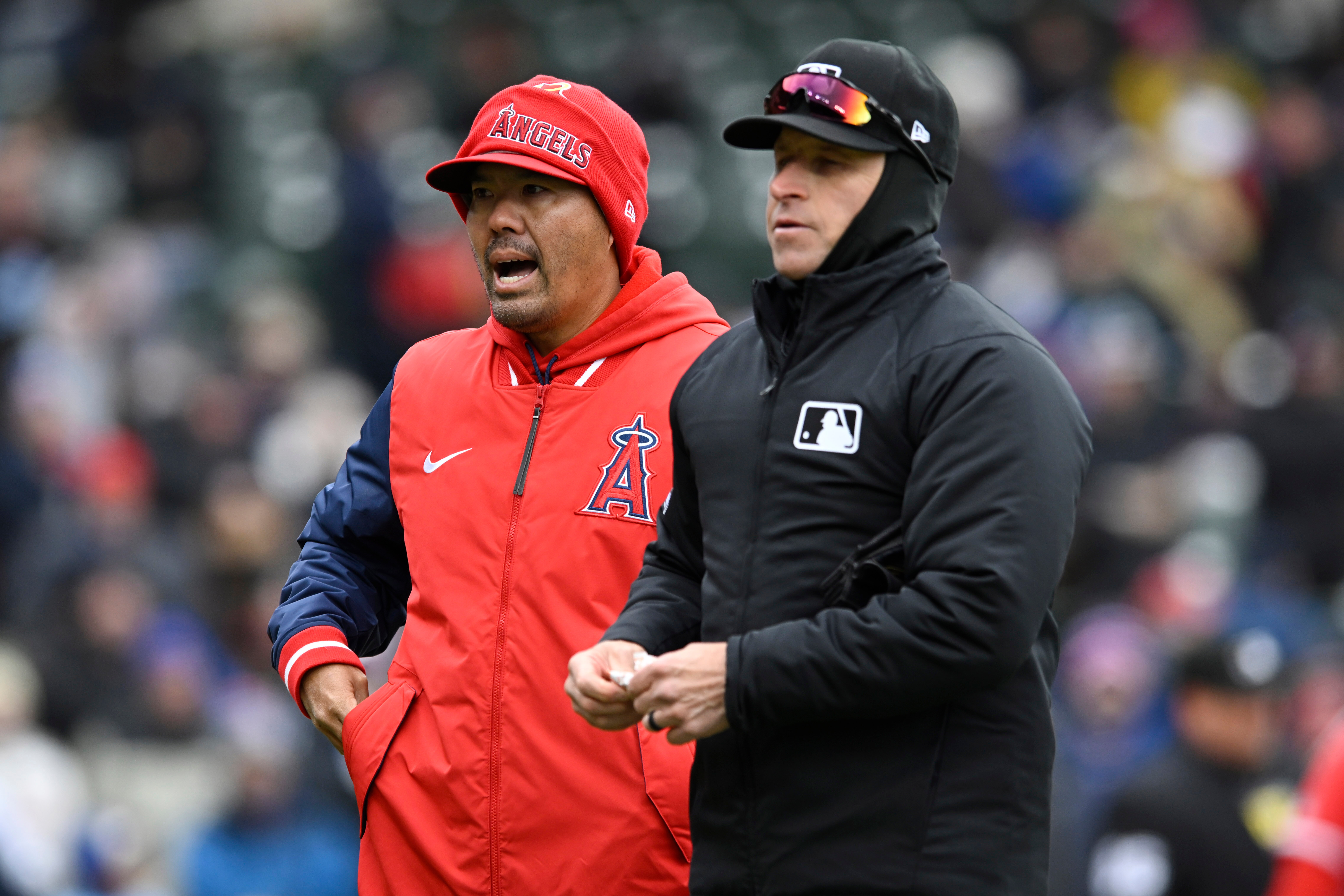 Angels manager Kurt Suzuki, left, attempts to challenge a play...