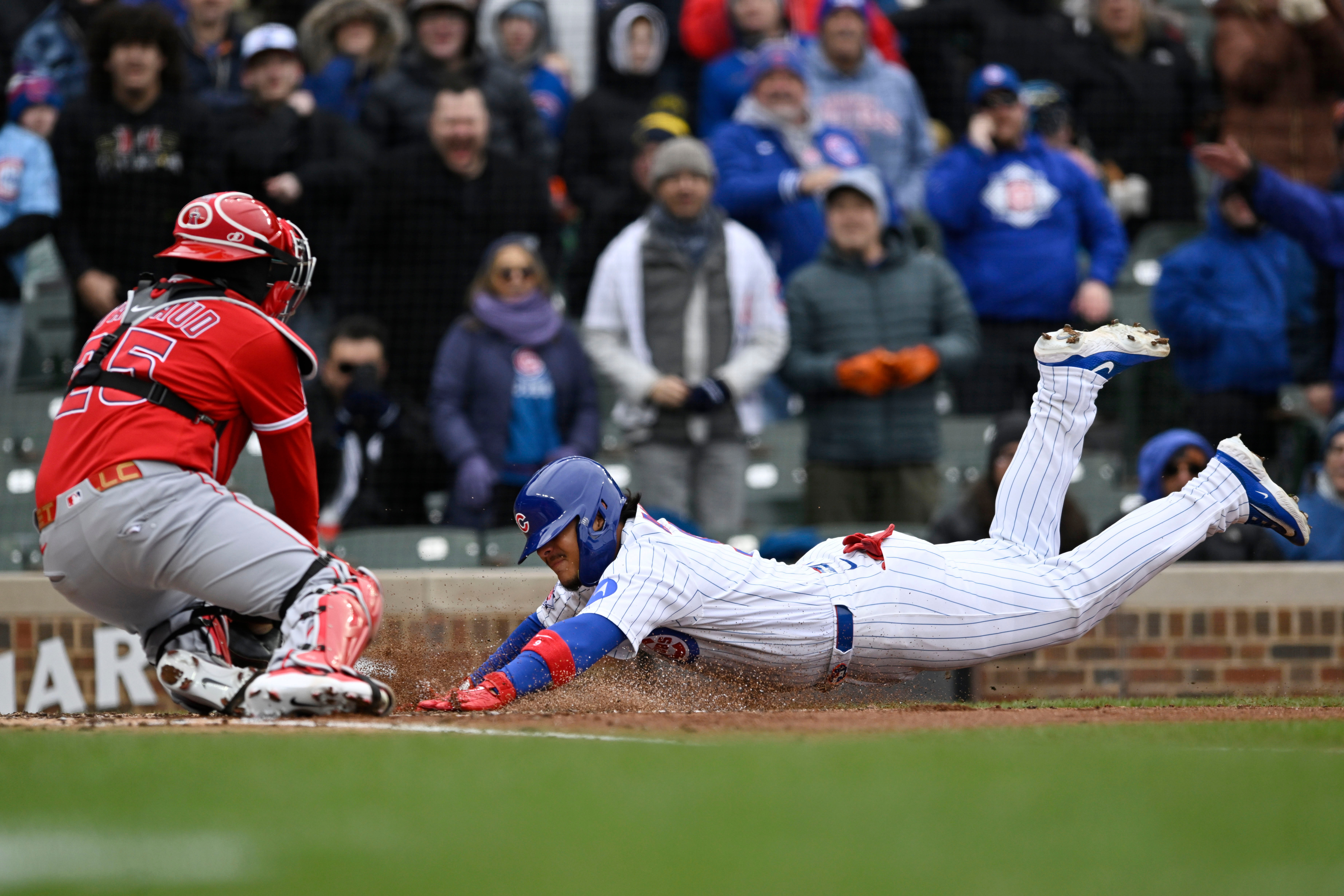 The Chicago Cubs’ Miguel Amaya slides home safely to score...