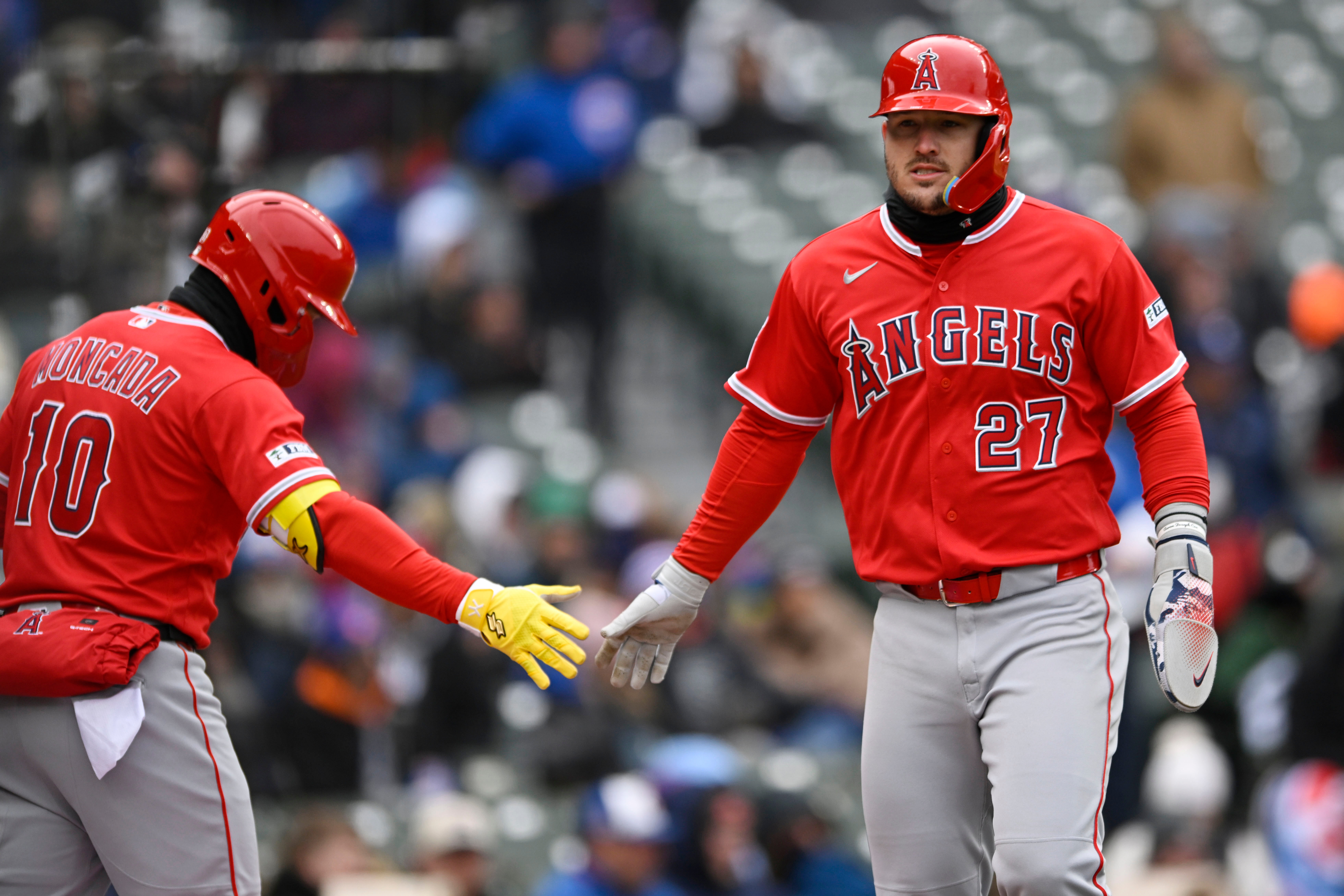 Angels star Mike Trout, right, celebrates with teammate Yoan Moncada...