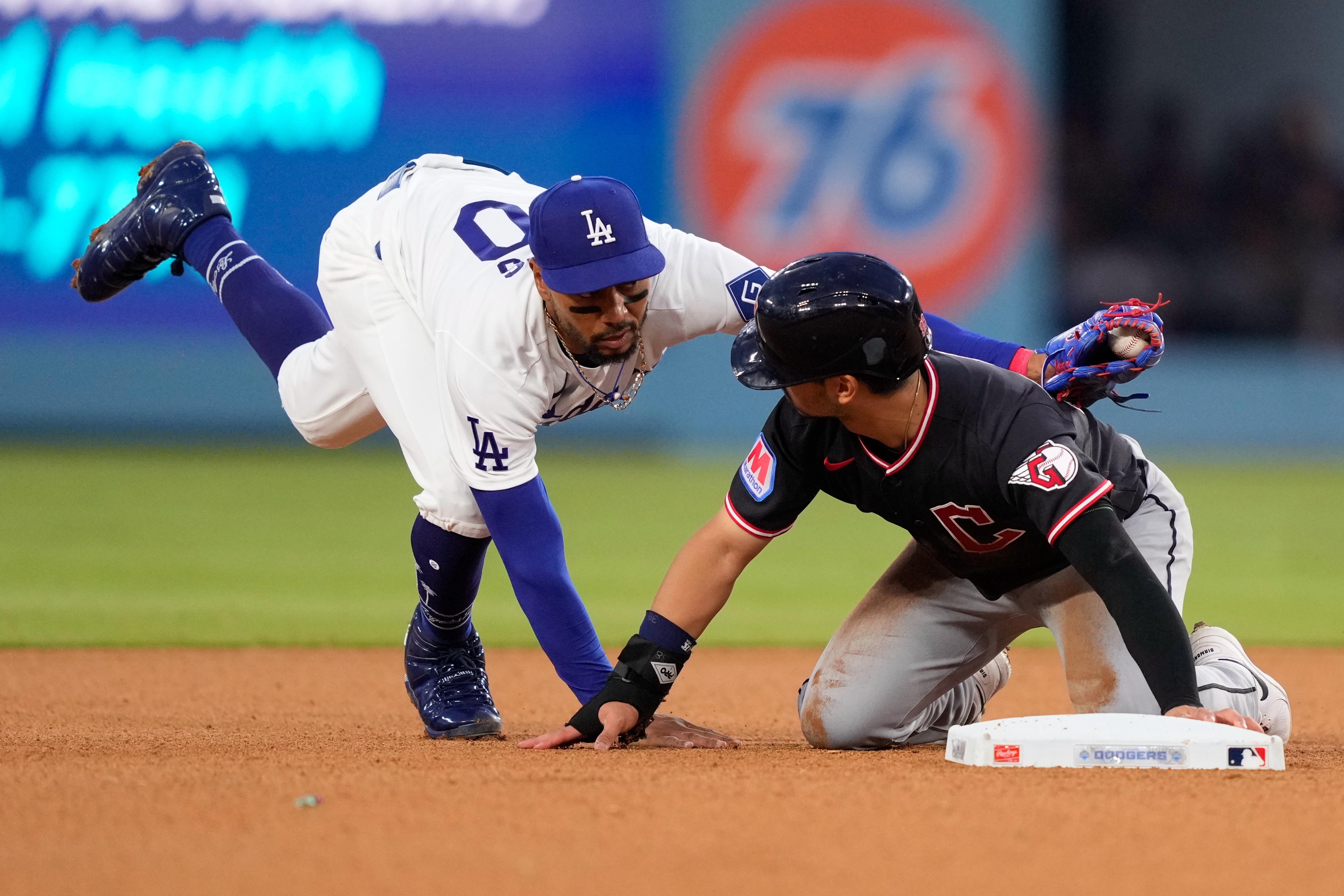 The Cleveland Guardians’ Steven Kwan, right, is tagged out by...