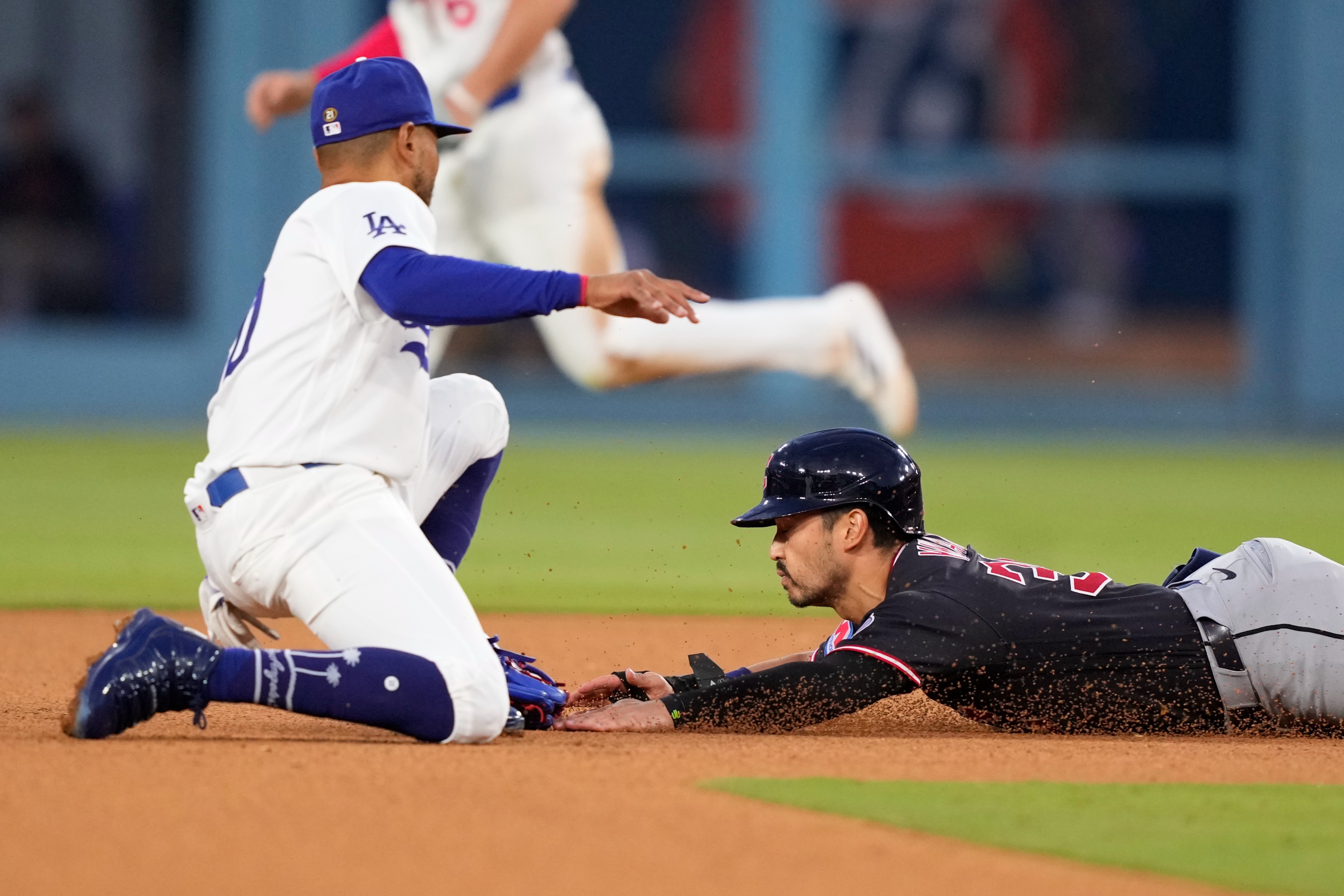 The Cleveland Guardians’ Steven Kwan, right, is tagged out by...