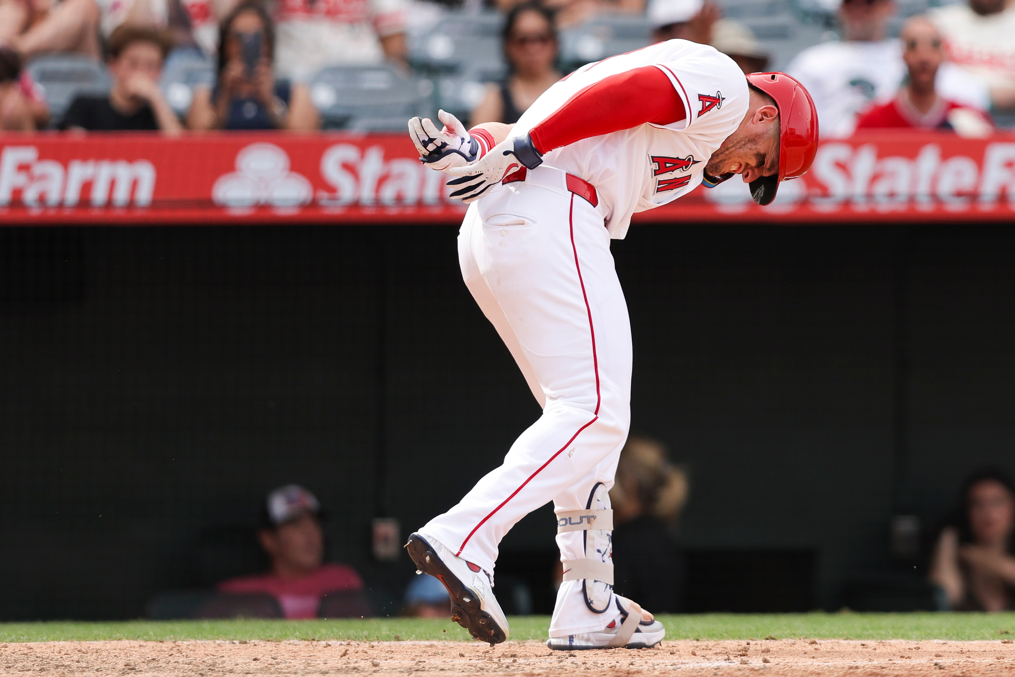 Angels’ Mike Trout reacts after being hit by a pitch...
