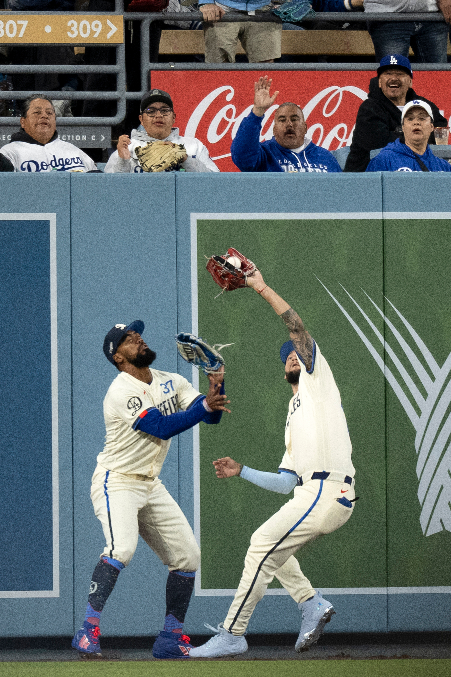 Dodgers center fielder Andy Pages, right, catches a fly ball...