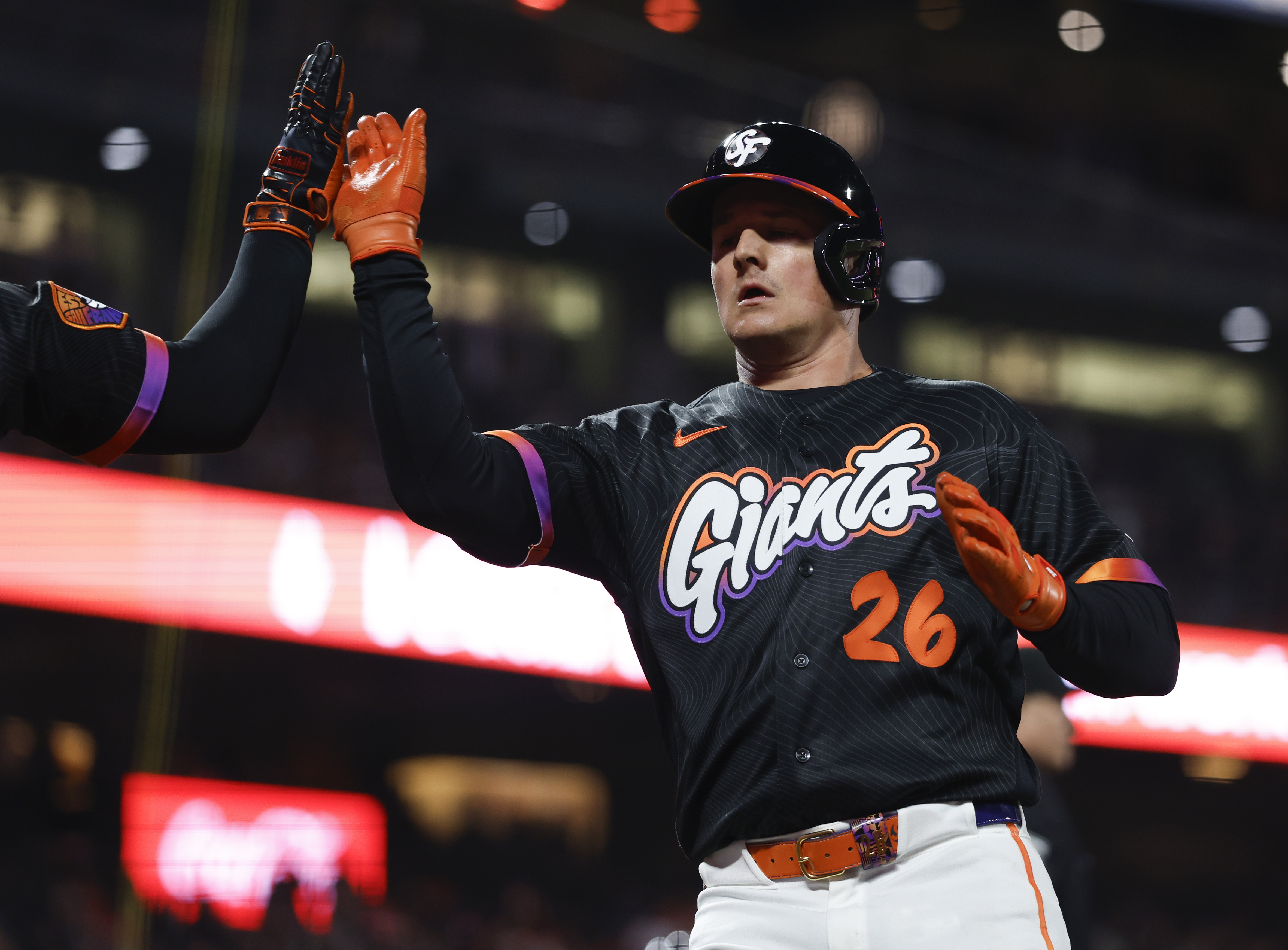 San Francisco Giants’ Matt Chapman (26) high-fives a teammate after...