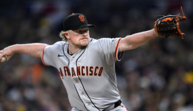 A San Francisco Giants pitcher is mid-throw, wearing a gray uniform and black cap, focused intently on the target during a game.