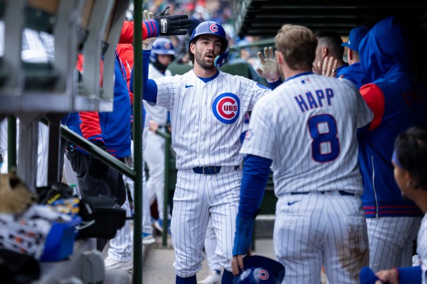 Chicago Cubs shortstop Dansby Swanson high fives teammates after scoring a run during the third inning of a game against the Los Angeles Angels at Wrigley Field in Chicago on Wednesday, April 1, 2026. (Josh Boland/Chicago Tribune)
