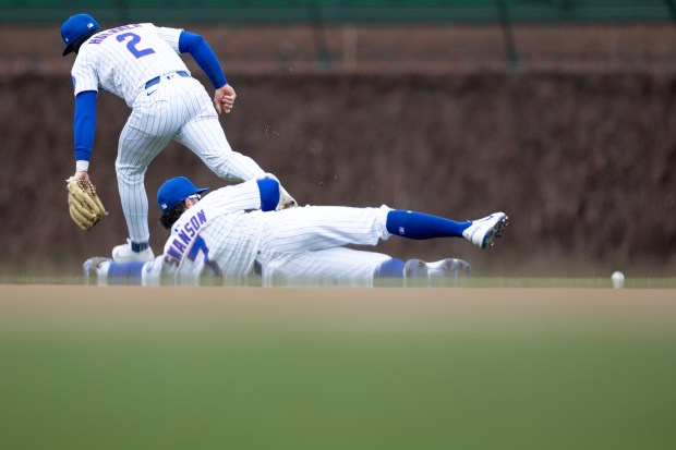 Chicago Cubs second baseman Nico Hoerner (2) and shortstop Dansby Swanson (7) both miss a ground ball during the sixth inning of a game against the Los Angeles Angels at Wrigley Field in Chicago on Wednesday, April 1, 2026. (Josh Boland/Chicago Tribune)