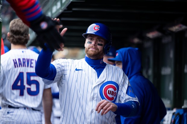 Chicago Cubs catcher Carson Kelly (15) high fives teammates after scoring during the seventh inning of a game against the Los Angeles Angels at Wrigley Field in Chicago on Wednesday, April 1, 2026. (Josh Boland/Chicago Tribune)
