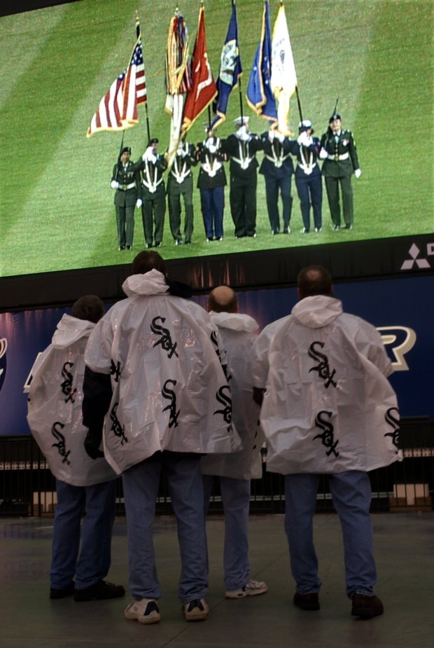 Four White Sox fans pause to observe a moment of silence for U.S. troops in Iraq prior to the White Sox home opener on April 4, 2003, at U.S. Cellular Field in Chicago. (Scott Strazzante/Chicago Tribune)