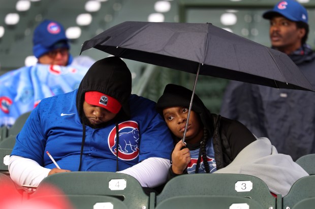 Chicago Cubs fans prepare for poor weather before the start of a game between the Cubs and the Los Angeles Angels at Wrigley Field in Chicago on March 31, 2026. (Chris Sweda/Chicago Tribune)