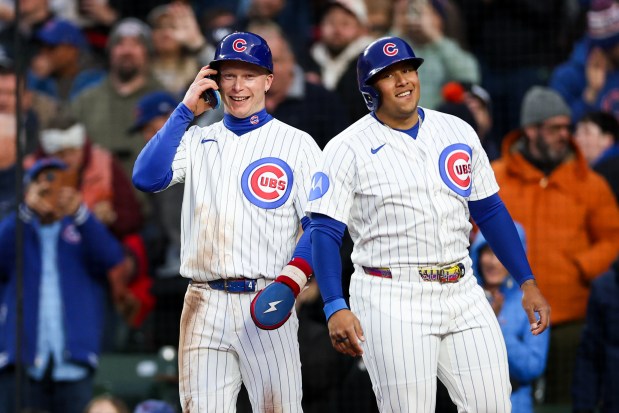 Cubs outfielder Pete Crow-Armstrong (4) and Cubs catcher Moisés Ballesteros (25) smile while watching Cubs shortstop Dansby Swanson (7) run to home plate after Swanson hit a three-run home run during the second inning against the Phillies at Wrigley Field April 20, 2026, in Chicago. (Armando L. Sanchez/Chicago Tribune)