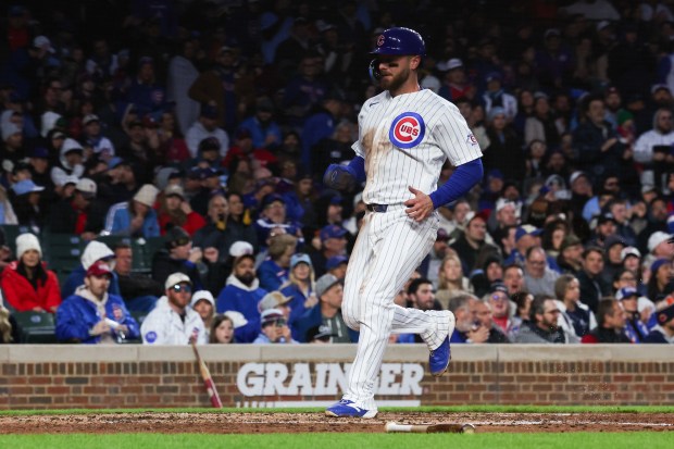 Cubs first baseman Michael Busch (29) scores off a sacrifice fly from Cubs left fielder Michael Conforto (20) during the third inning at Wrigley Field April 20, 2026, in Chicago. (Armando L. Sanchez/Chicago Tribune)