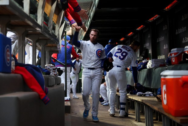 Cubs left fielder Ian Happ (8) celebrates in the dugout after scoring off Cubs catcher Miguel Amaya (9) after he grounded into a double play allowing Happ to score during the second inning against the Phillies at Wrigley Field April 20, 2026, in Chicago. (Armando L. Sanchez/Chicago Tribune)