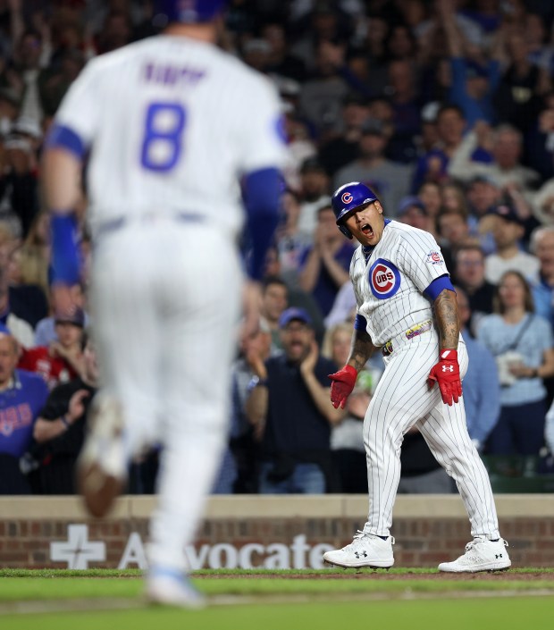Chicago Cubs pinch hitter Moisés Ballesteros (25) celebrates after drawing a run-scoring walk in the fifth inning as Ian Happ (8) trots in to score on the play against the Philadelphia Phillies at Wrigley Field in Chicago on April 21, 2026. (Chris Sweda/Chicago Tribune)