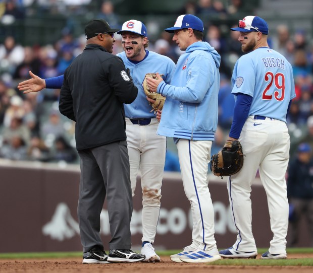 Chicago Cubs second baseman Nico Hoerner (second from left), manager Craig Counsell, and first baseman Michael Busch (29), argue a call after a stolen base by Pittsburgh Pirates center fielder Oneil Cruz in the seventh inning of a game at Wrigley Field in Chicago on April 10, 2026. (Chris Sweda/Chicago Tribune)