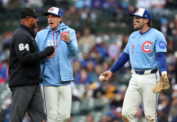 Chicago Cubs manager Craig Counsell and second baseman Nico Hoerner (right) manager Craig Counsell argue a call with second base umpire Alan Porter (64) after a stolen base by Pittsburgh Pirates center fielder Oneil Cruz in the seventh inning of a game at Wrigley Field in Chicago on April 10, 2026. (Chris Sweda/Chicago Tribune)