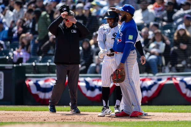 Toronto Blue Jays first baseman Vladimir Guerrero Jr. (27) taps Chicago White Sox second baseman Luisangel Acuña (0) on his helmet at first base during the second inning of a game against the Toronto Blue Jays at Rate Field on Sunday, April 5, 2026. (Josh Boland/Chicago Tribune)