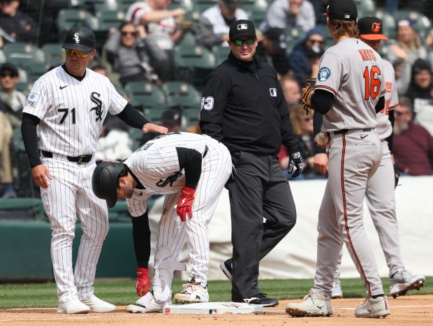 White Sox third base coach Justin Jirschele (71) congratulates left fielder Andrew Benintendi after hitting a triple against the Orioles in the second inning at Rate Field on April 8, 2026, in Chicago. (John J. Kim/Chicago Tribune)
