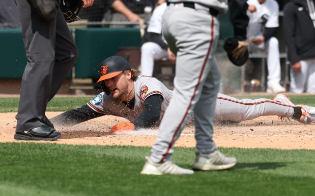 Orioles shortstop Gunnar Henderson slides home on a double from left fielder Taylor Ward in the third inning against the White Sox at Rate Field on April 8, 2026, in Chicago. (John J. Kim/Chicago Tribune)
