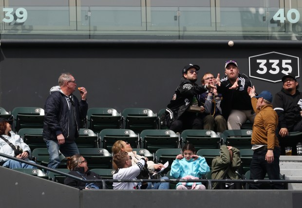 Fans reach for a foul ball in the third inning of a White Sox-Orioles game at Rate Field on April 8, 2026, in Chicago. (John J. Kim/Chicago Tribune)