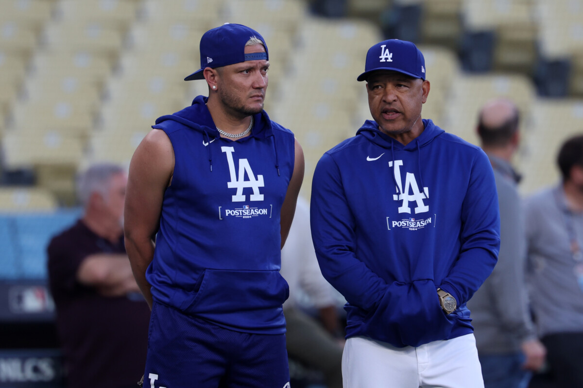 Oct 12, 2024; Los Angeles, CA, USA; Los Angeles Dodgers manager Dave Roberts (right) speaks to shortstop Miguel Rojas (left) during the NLCS workouts at Dodgers Stadium. Mandatory Credit: Kiyoshi Mio-Imagn Images