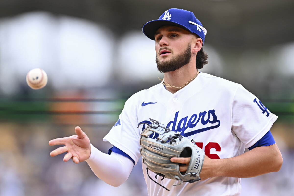 Apr 12, 2026; Los Angeles, California, USA; Los Angeles Dodgers second baseman Alex Freeland (76) tosses the ball to first base to force an out against the Texas Rangers during the fifth inning at Dodger Stadium. Mandatory Credit: Jonathan Hui-Imagn Images