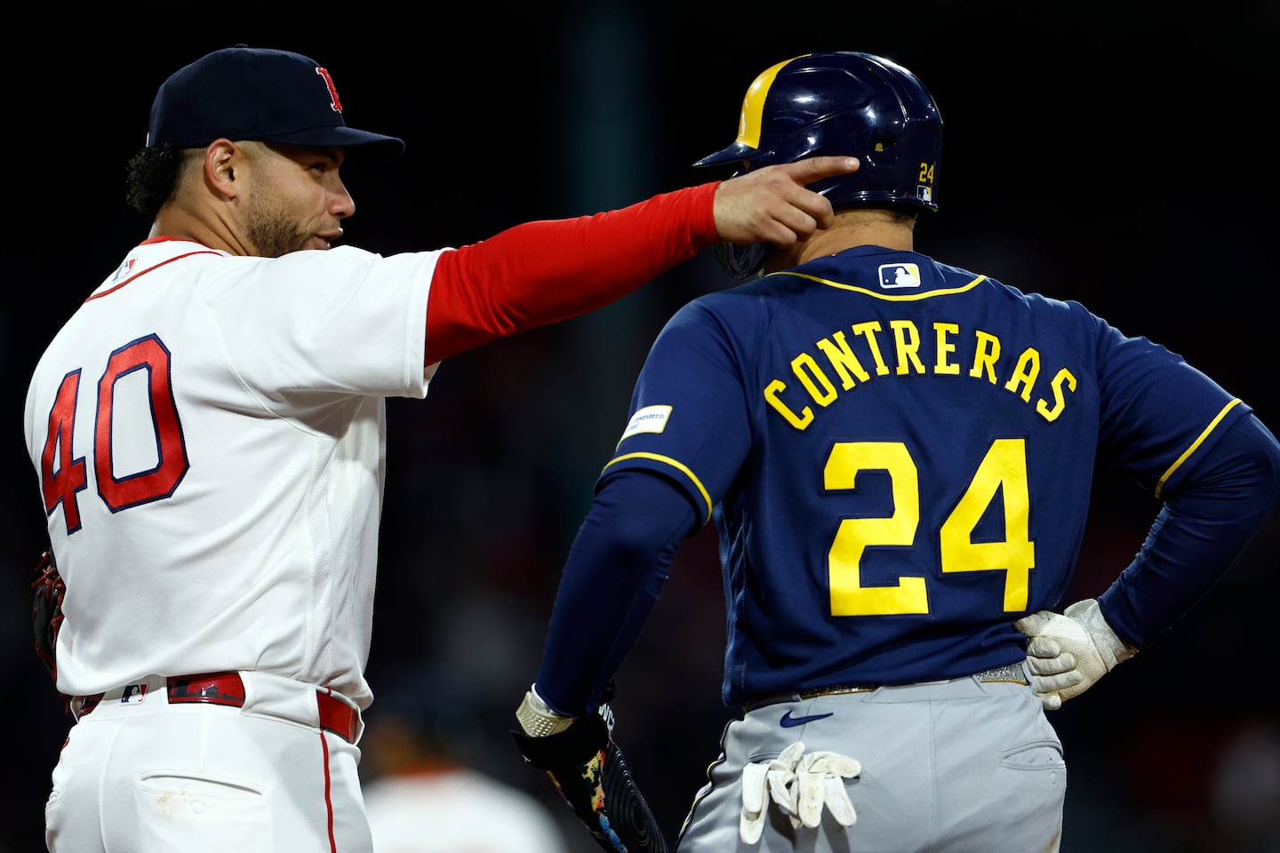 Willson Contreras (lefts) talks to his brother, Brewers catcher William Contreras, during the third inning Monday at Fenway Park as the Red Sox tried to get themselves pointed in the right direction.