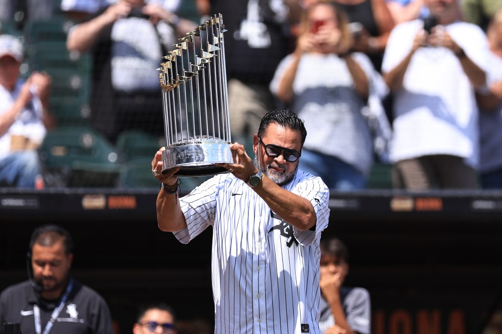 Ozzie Guillén, World Series winning manager with the Chicago White Sox, lifts the World Series trophy during a ceremony commemorating the 2005 Chicago White Sox team at Rate Field on July 12, 2025 in Chicago, Illinois. 