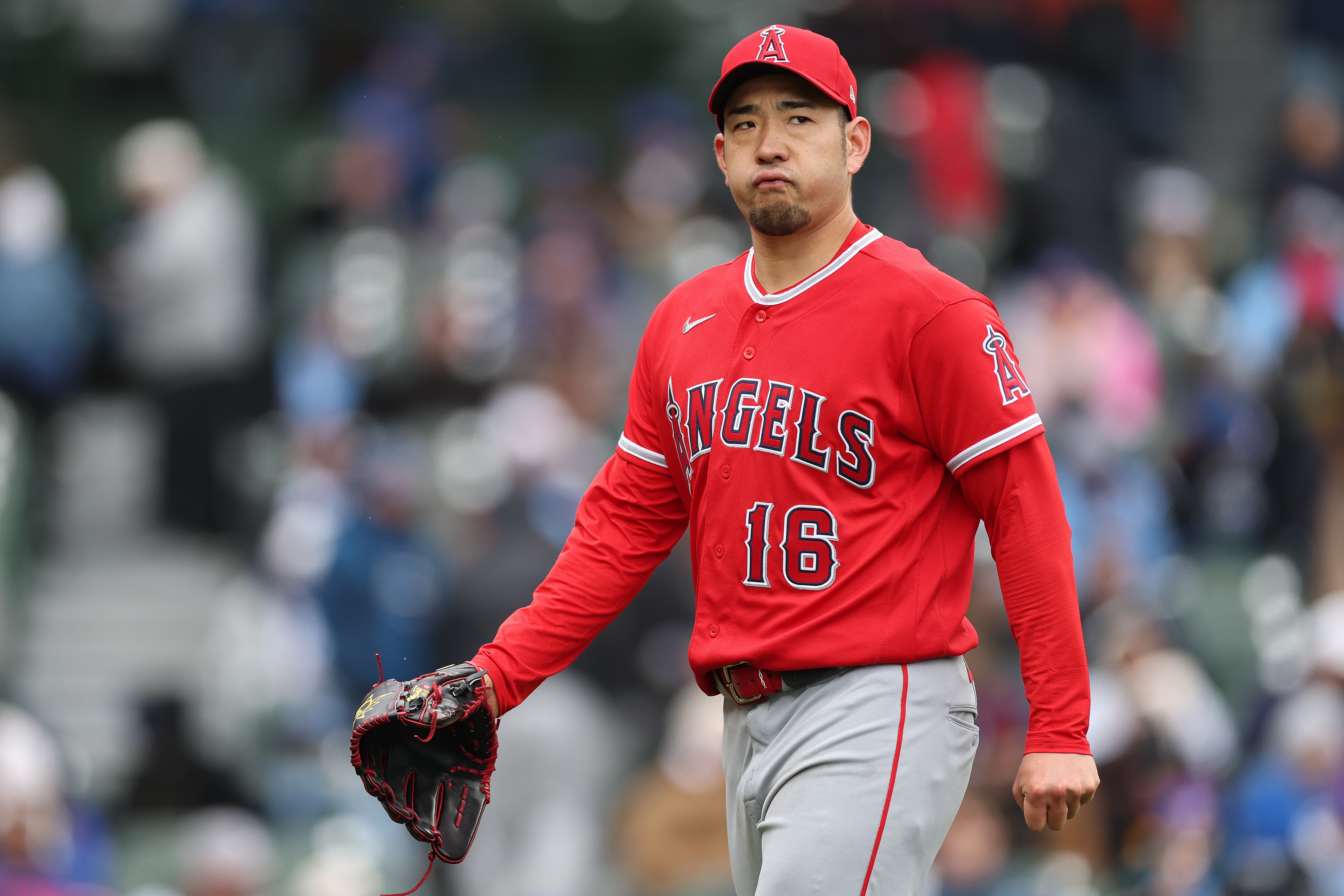 Angels starting pitcher Yusei Kikuchi reacts as he walks off...