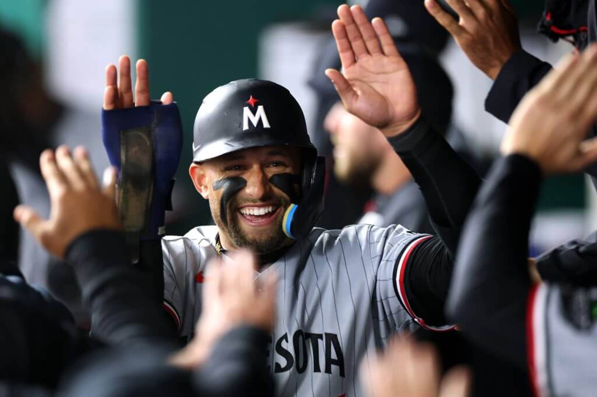 Royce Lewis is congratulated by teammates giving him high-fives.
