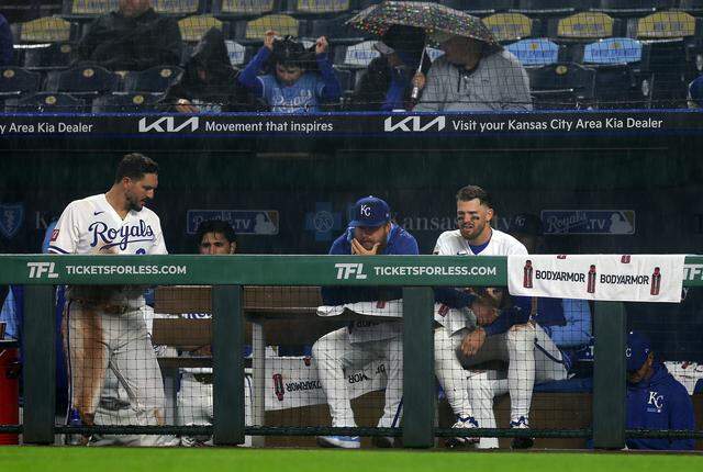 First baseman Vinnie Pasquantino #9 and shortstop Bobby Witt Jr. #7 of the Kansas City Royals watch from the dugout in the rain during the 5th inning against the Minnesota Twins at Kauffman Stadium on April 1, 2026 in Kansas City.