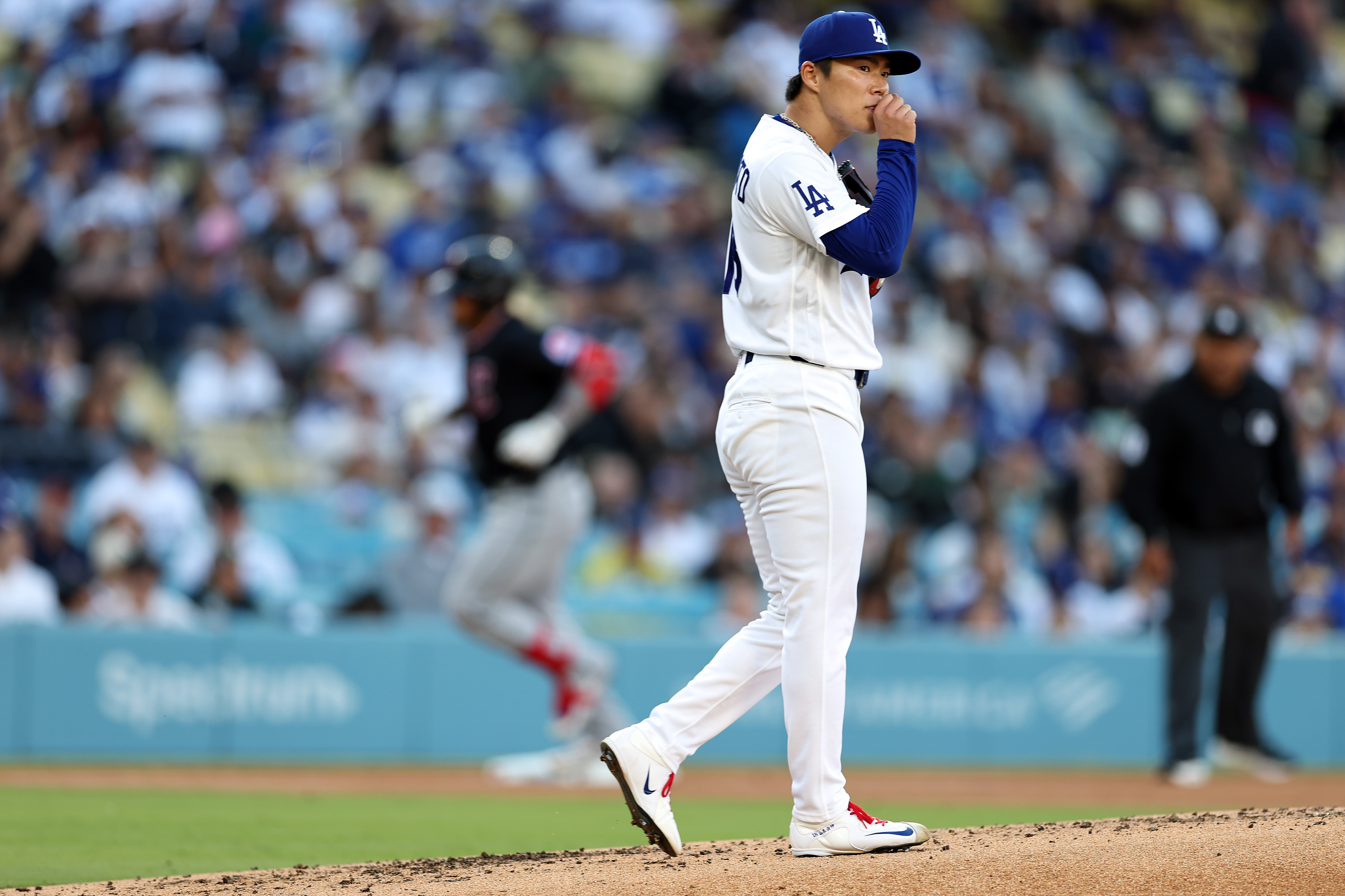 Dodgers starting pitcher Yoshinobu Yamamoto gathers himself after giving up...