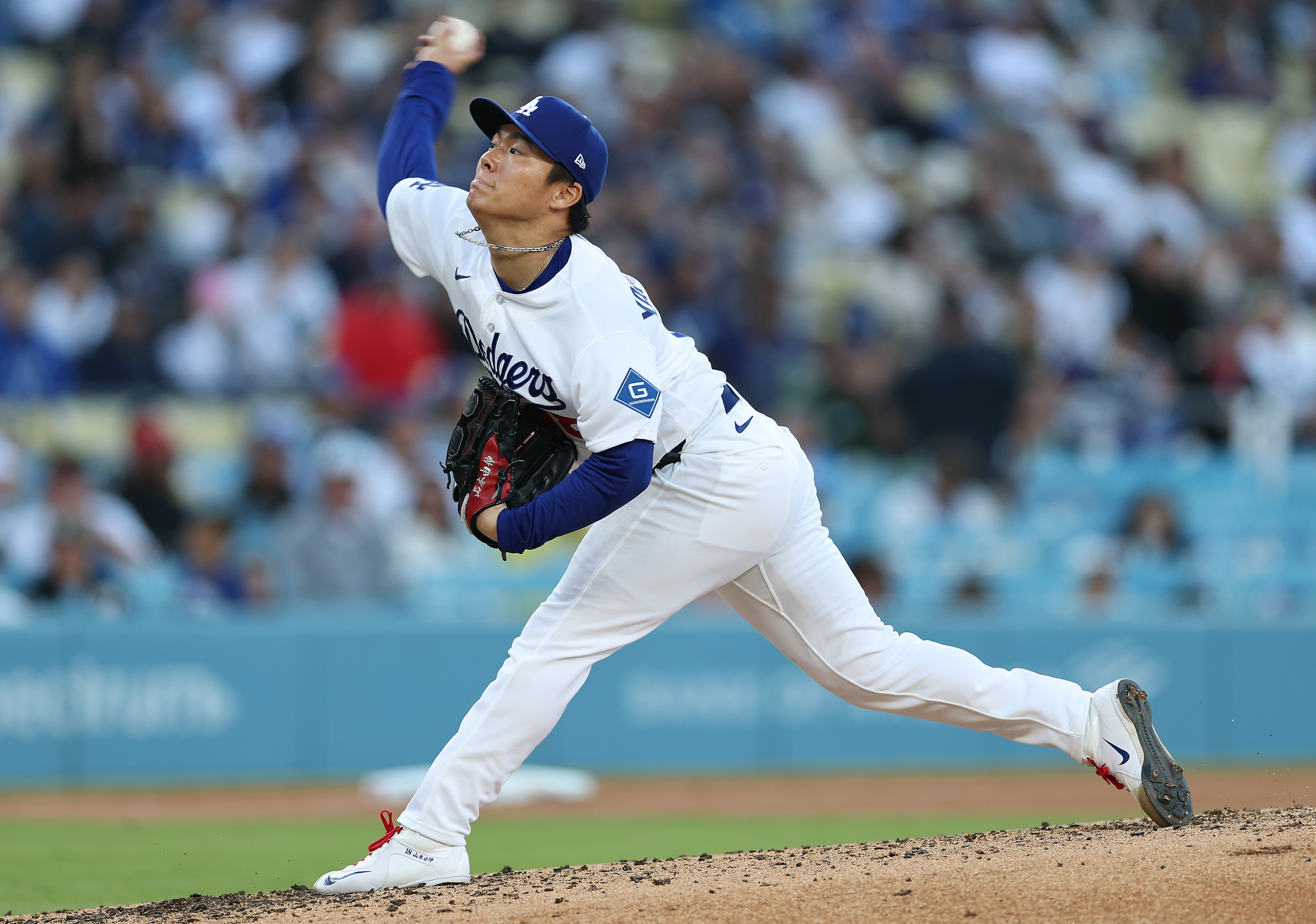 Dodgers starting pitcher Yoshinobu Yamamoto throws to the plate during...