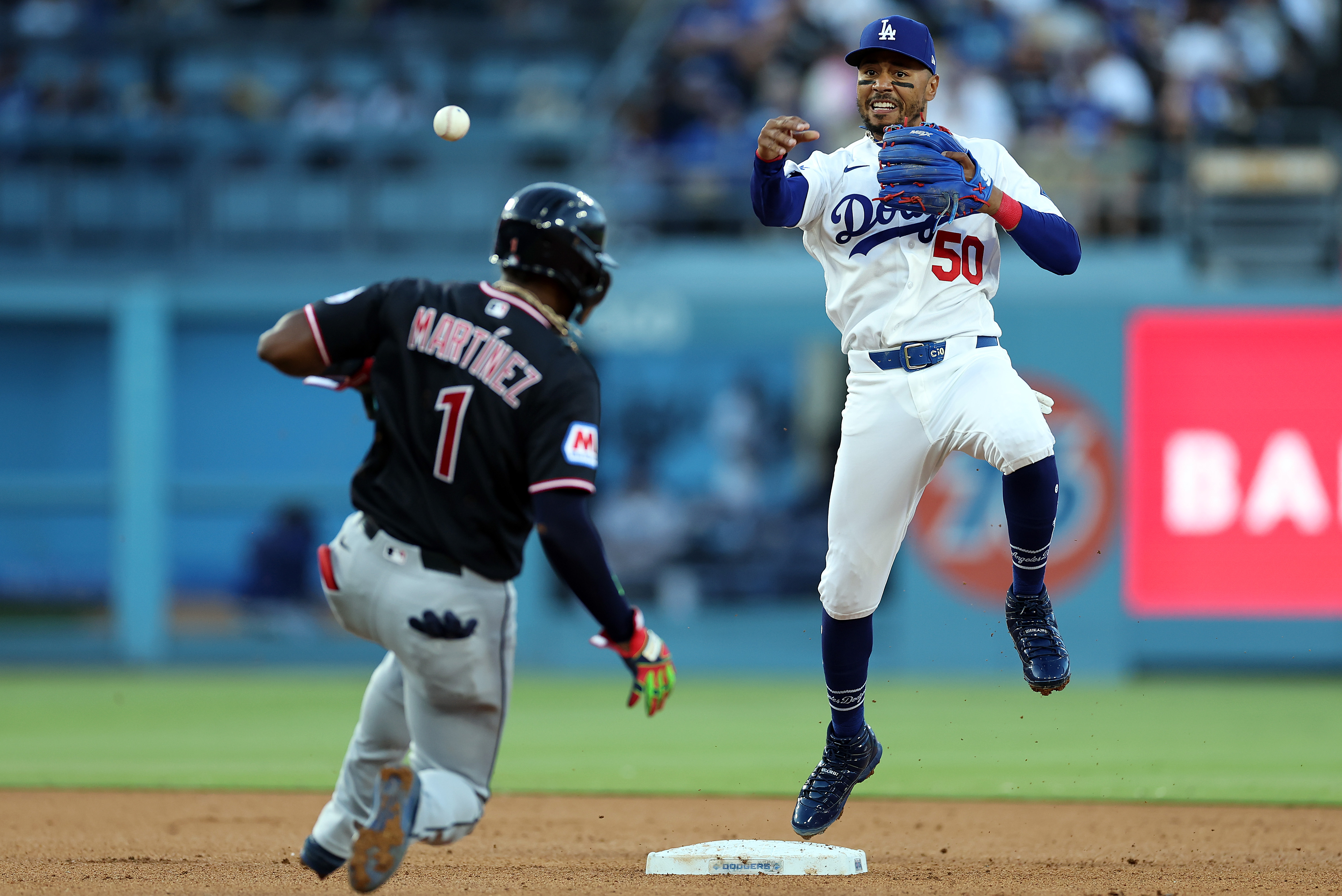 Dodgers shortstop Mookie Betts throws to first base to complete...