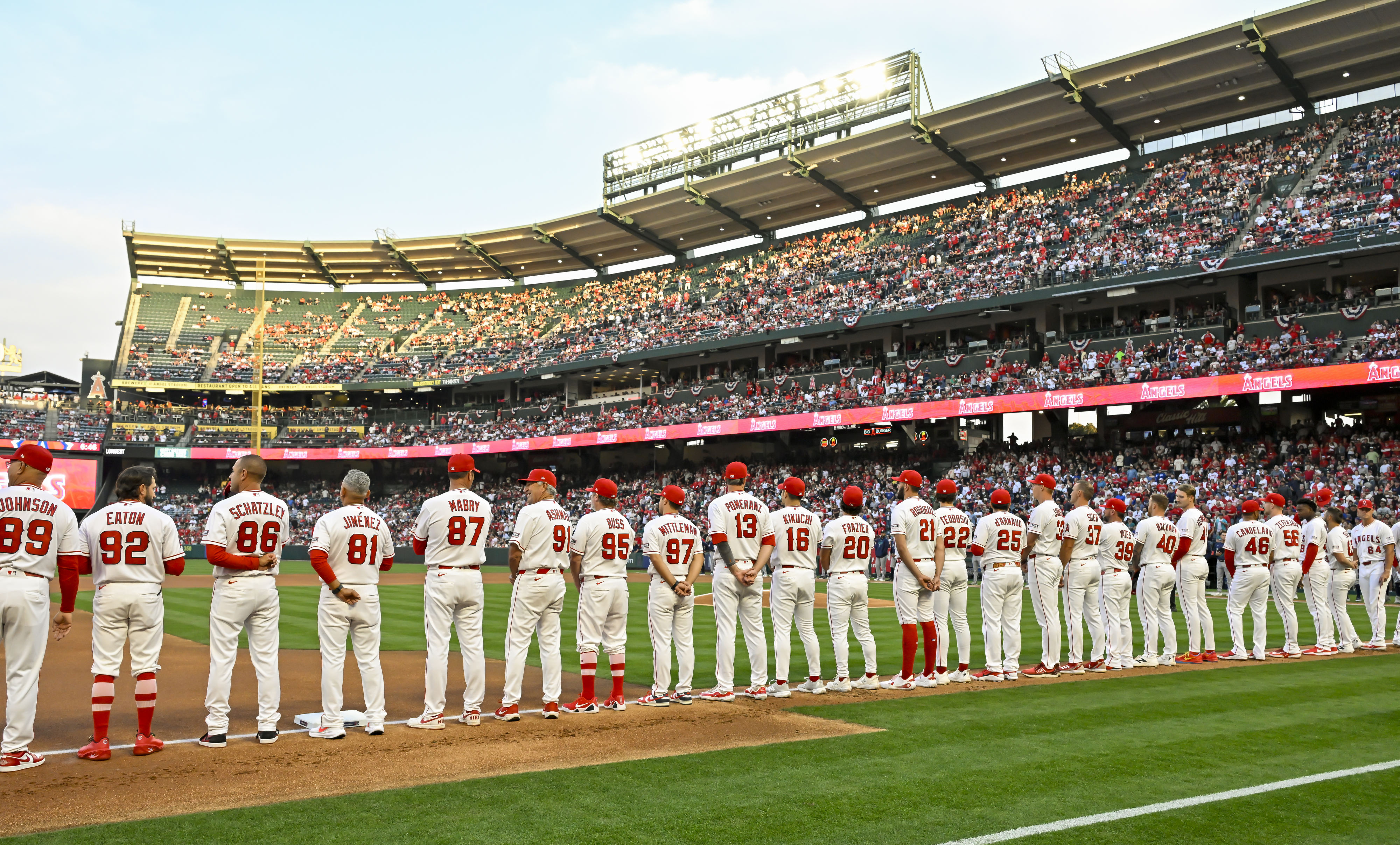 Angels players and coaches line up on third base line...