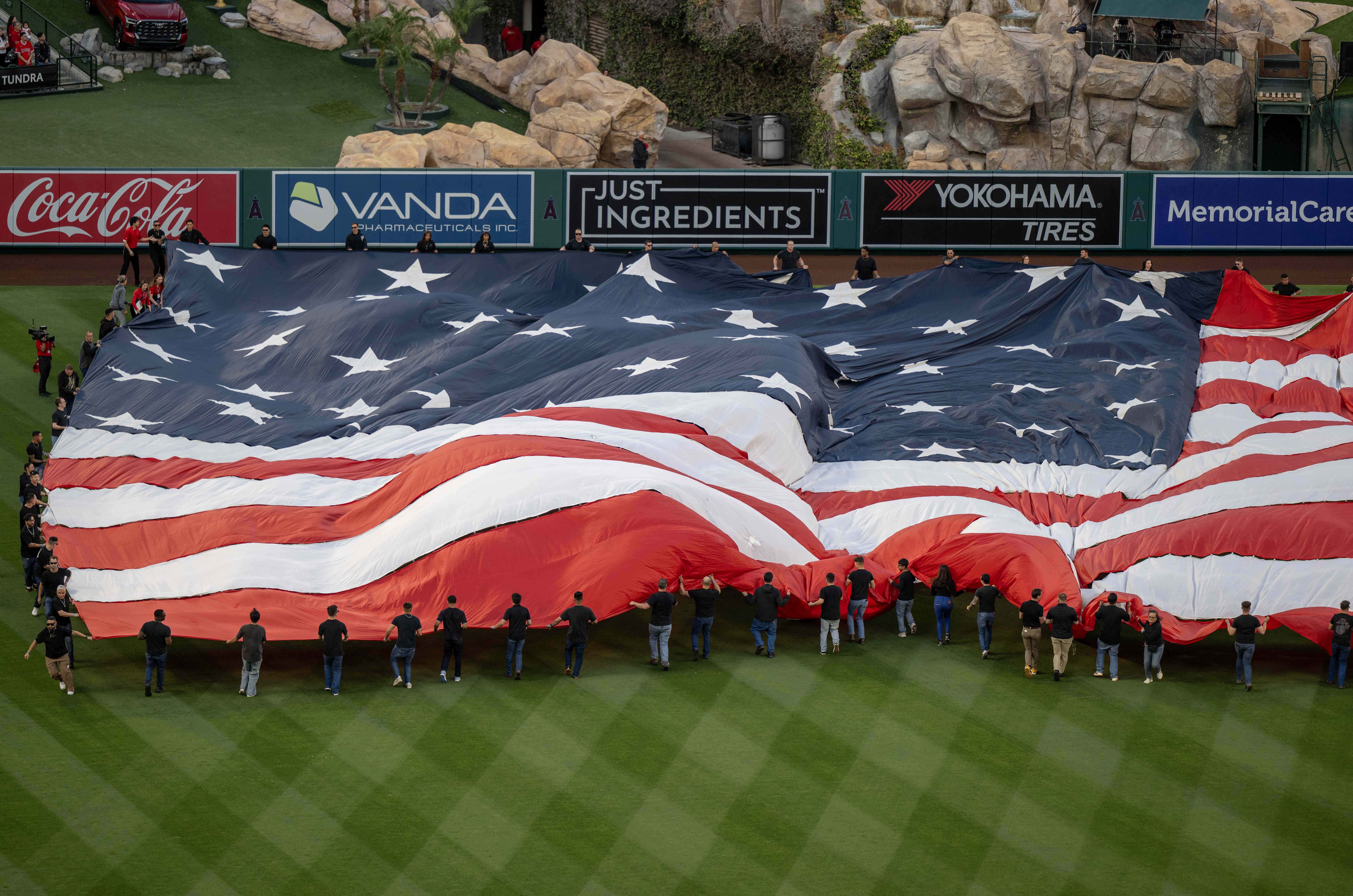 A giant American flag is unfurled during the National Anthem...