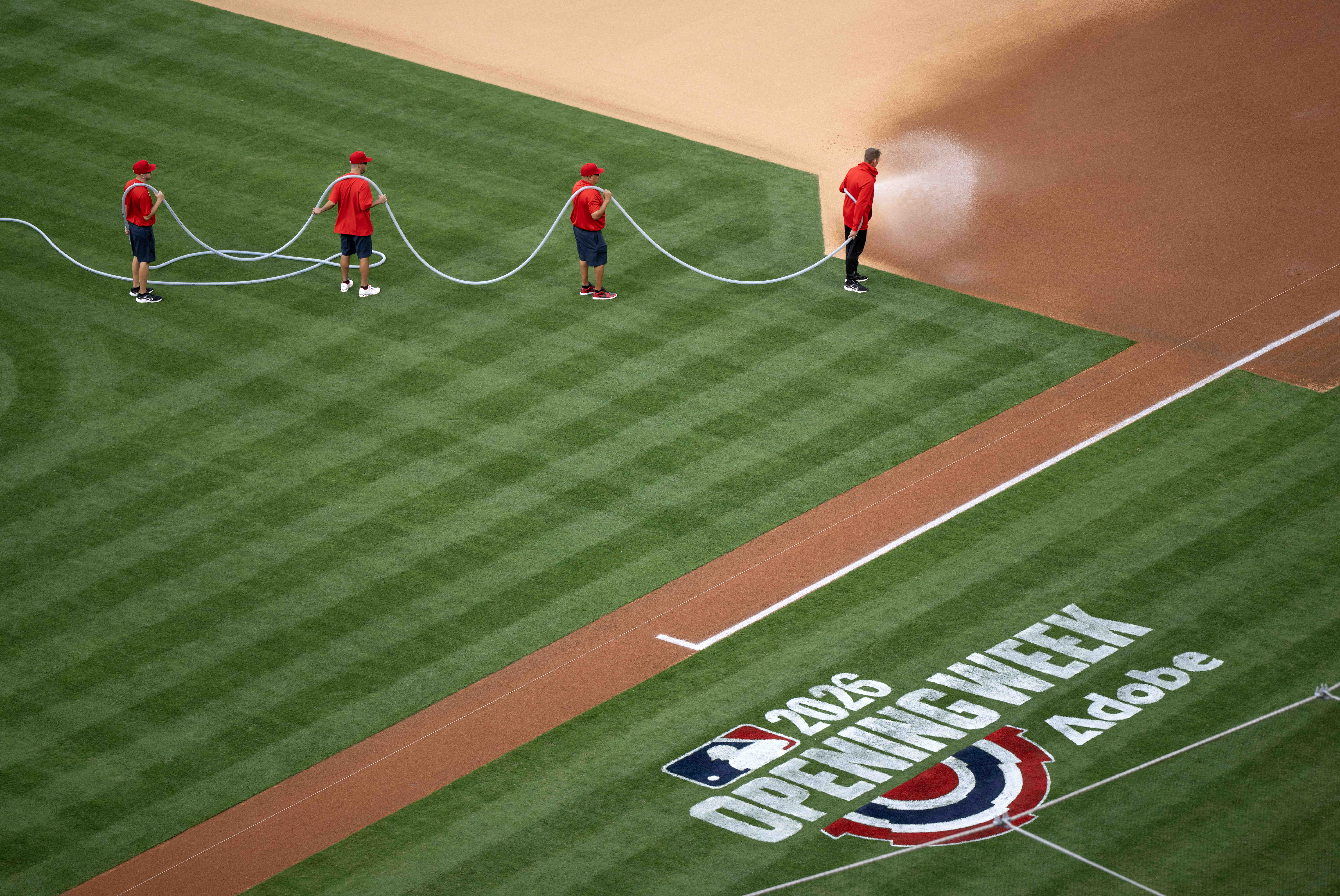 Grounds crews prepare the field for the start of the...