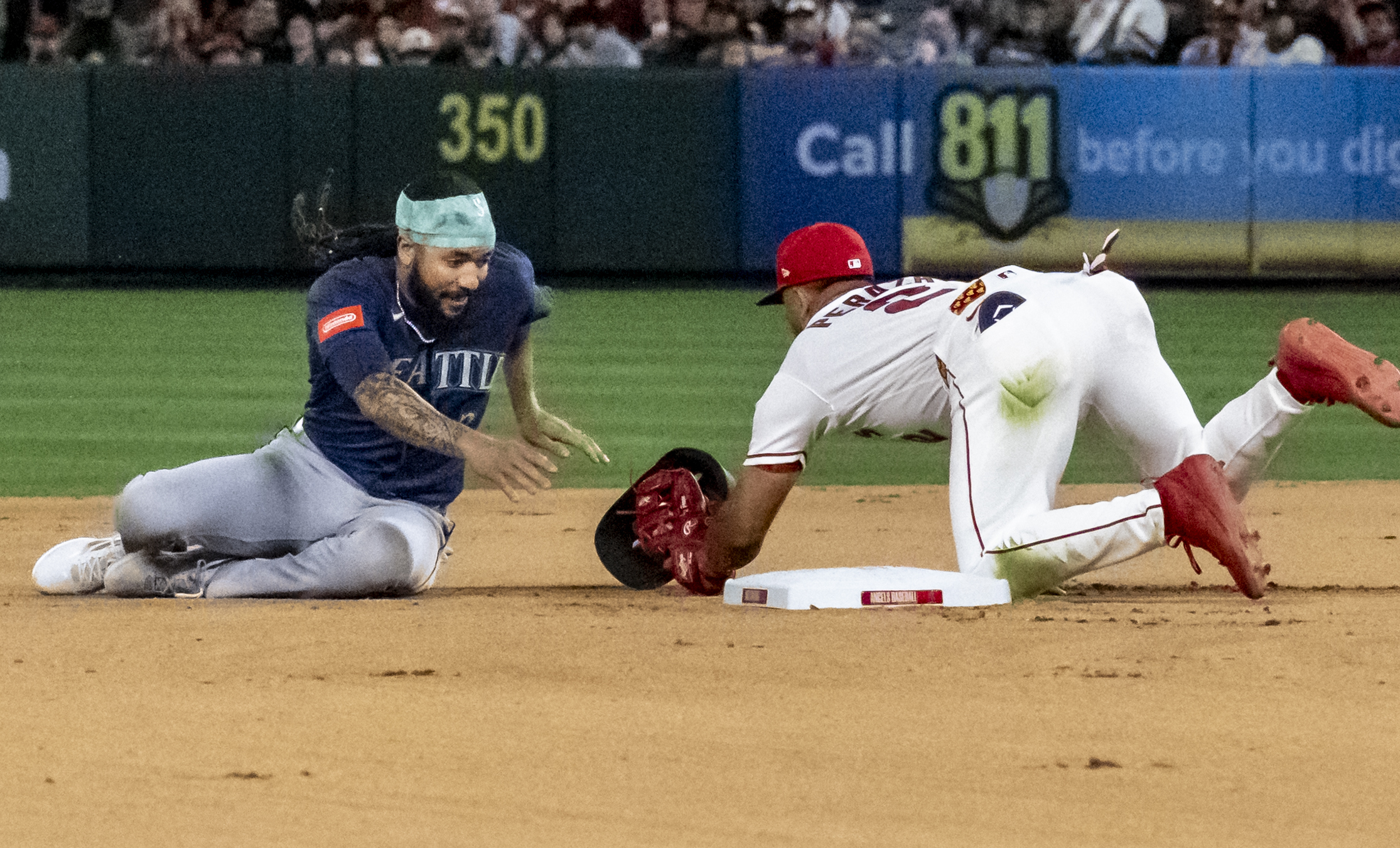 Angels second baseman Oswald Peraza, right, tags the Seattle Mariners’...
