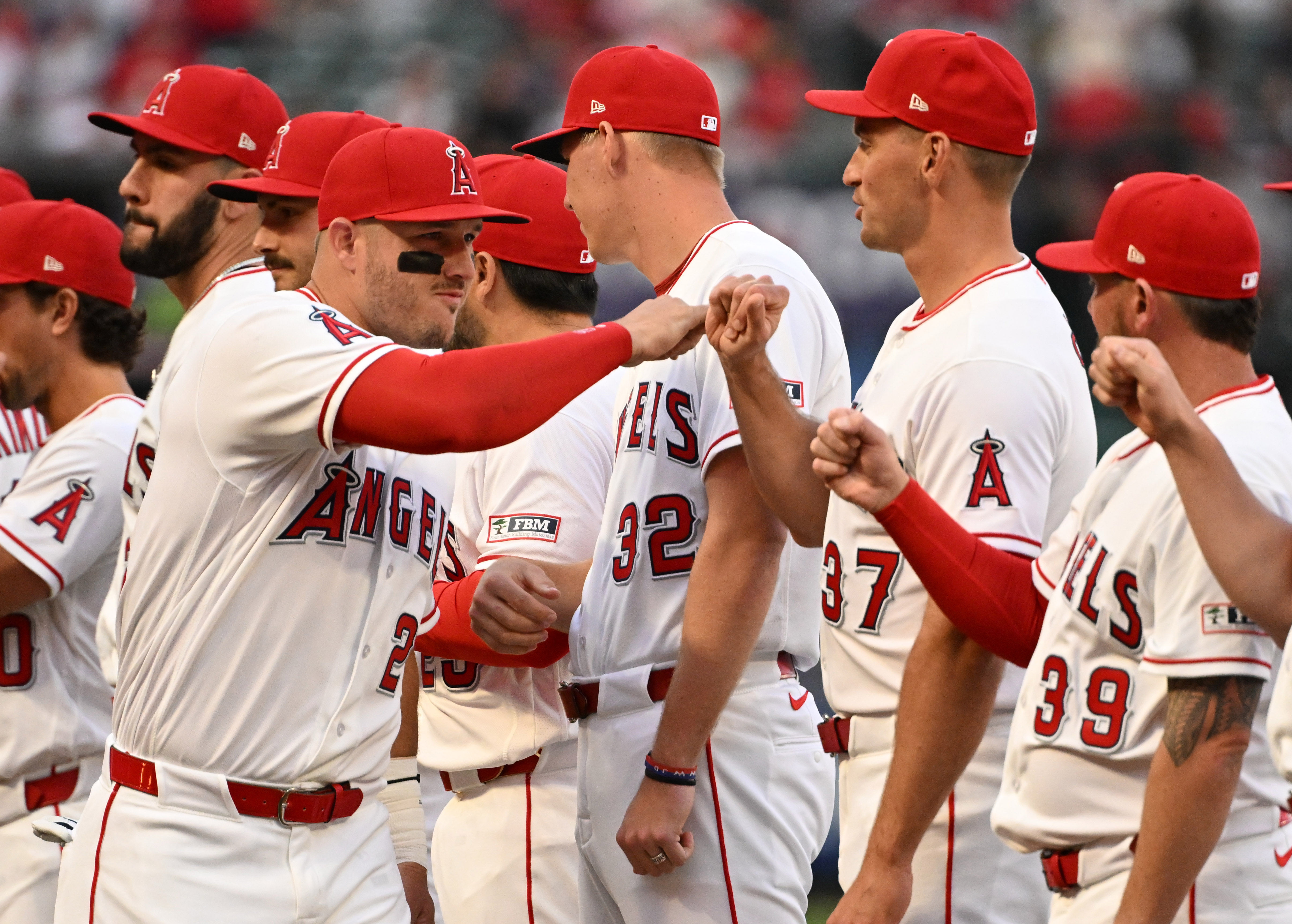 Mike Trout #27 of the Los Angeles Angels high fives...