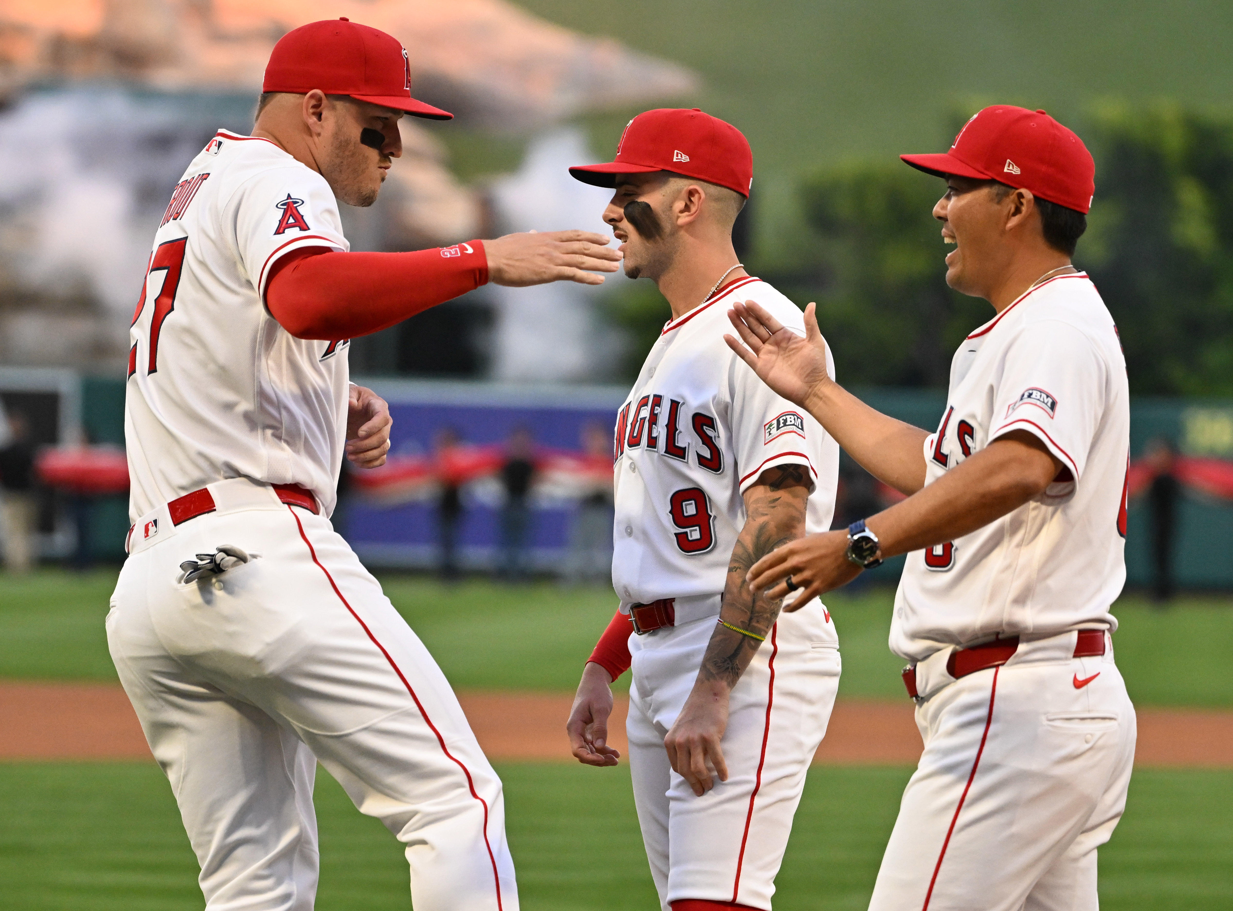 Mike Trout #27 high fievs manager Kurt Suzuki #8 of...