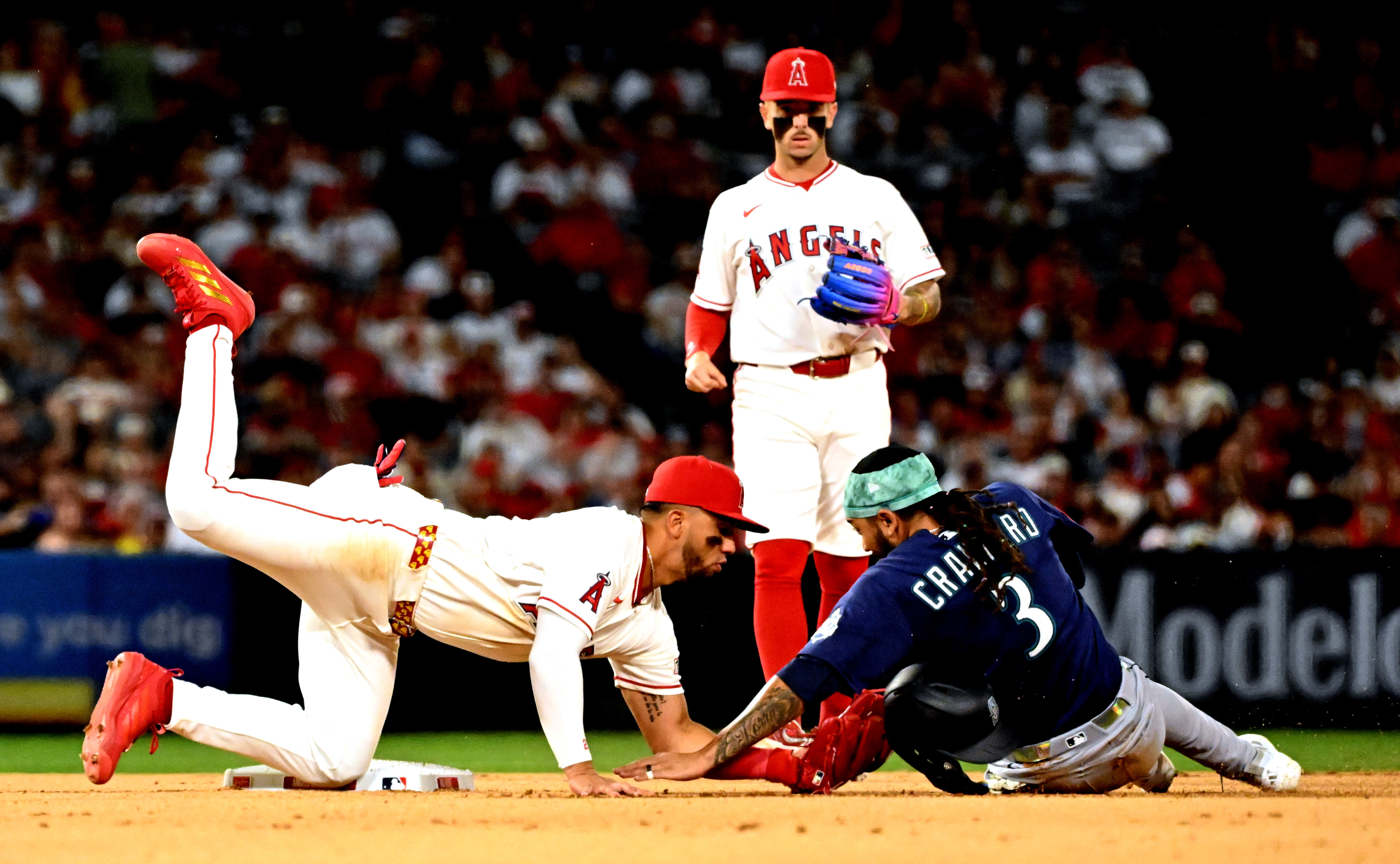 Angels second baseman Oswald Peraza, left, tags the Seattle Mariners’...