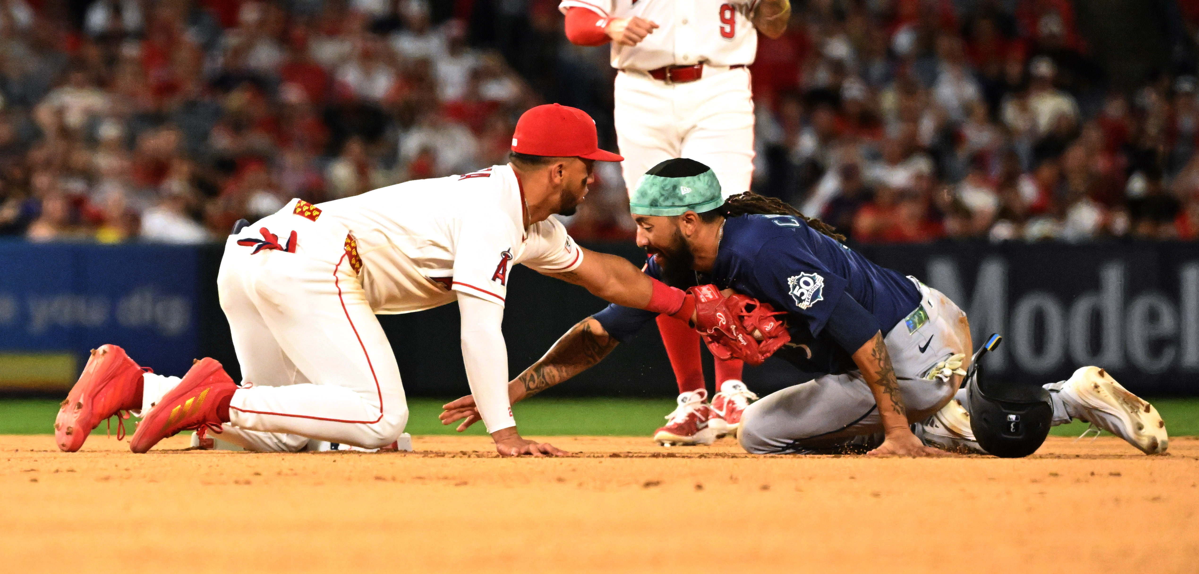 Angels second baseman Oswald Peraza, left, tags the Seattle Mariners’...