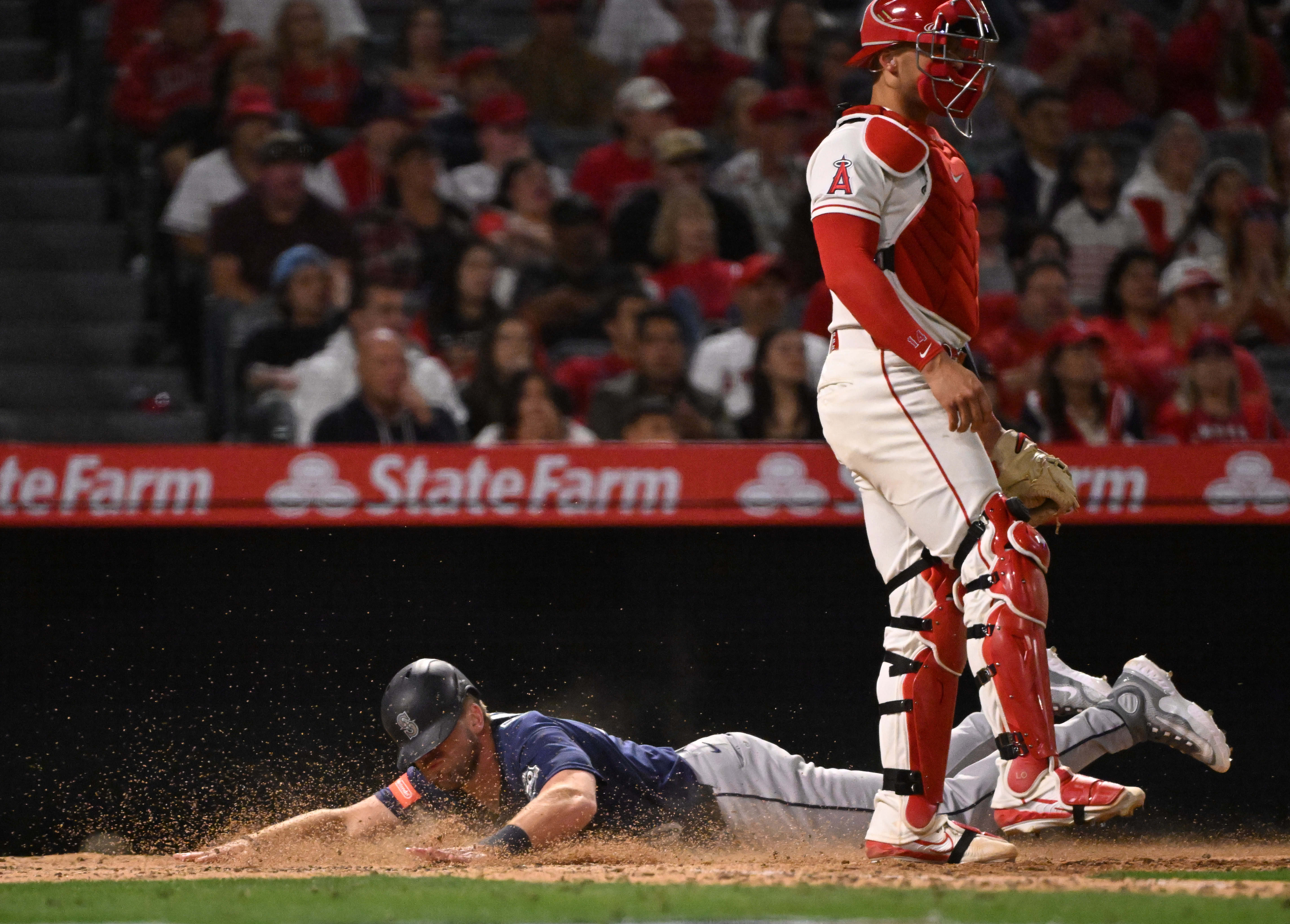 Luke Raley #20 of the Seattle Mariners scores on a...
