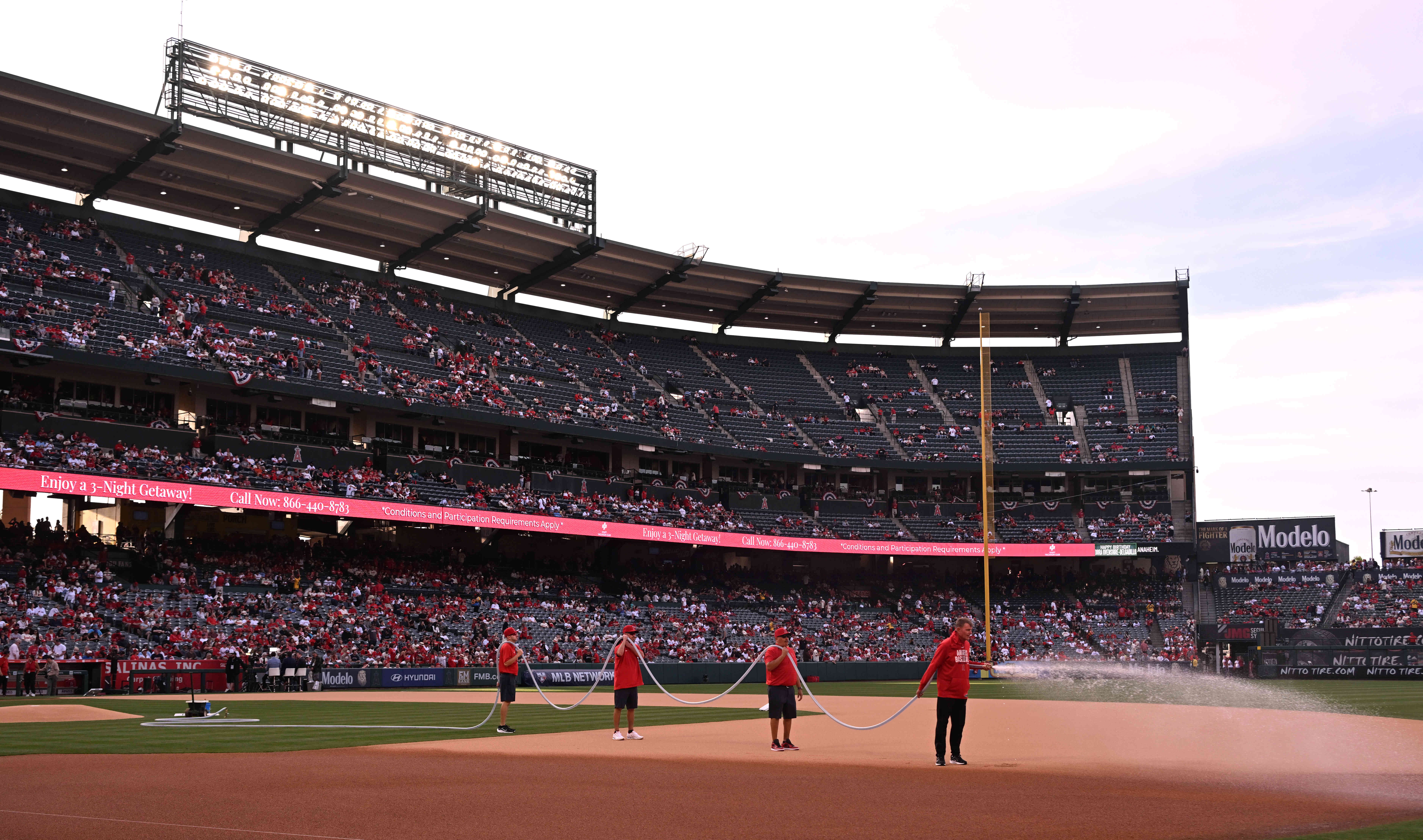 Angels grounds crew members water down the infield before the...