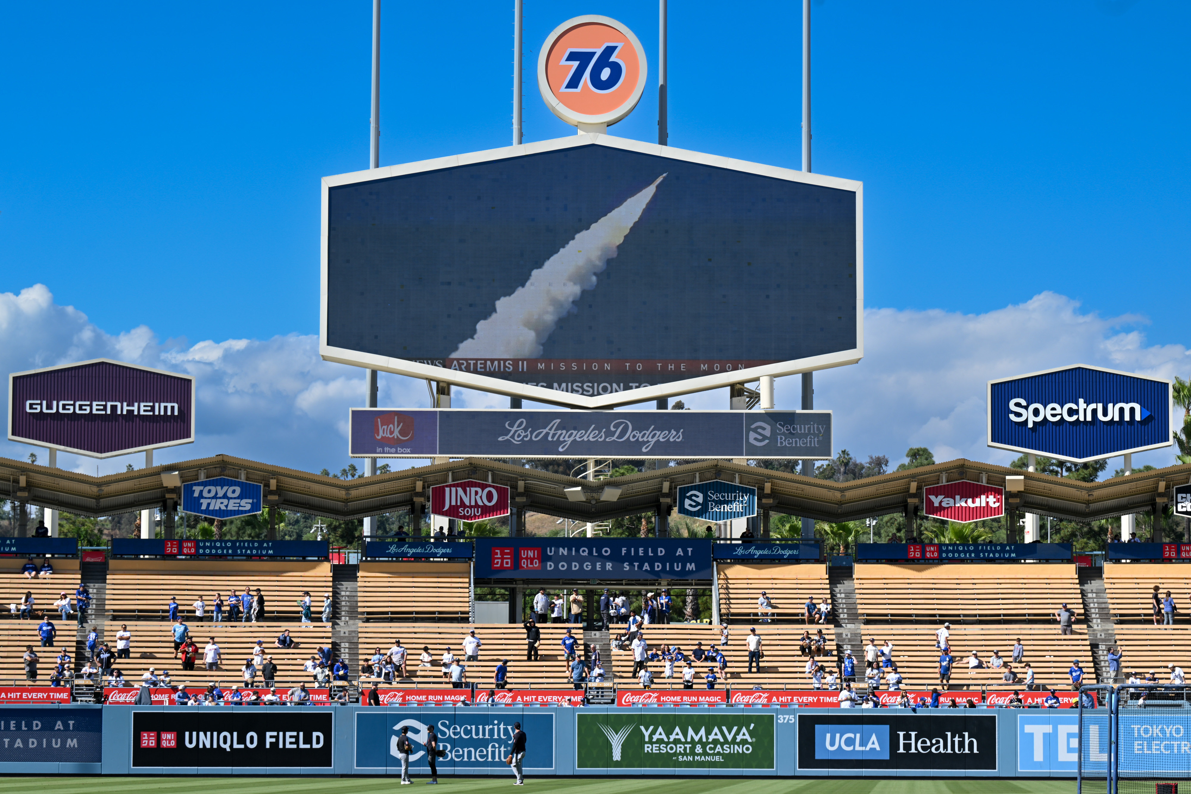 Players and fans watch the Artemis II rocket lift off...