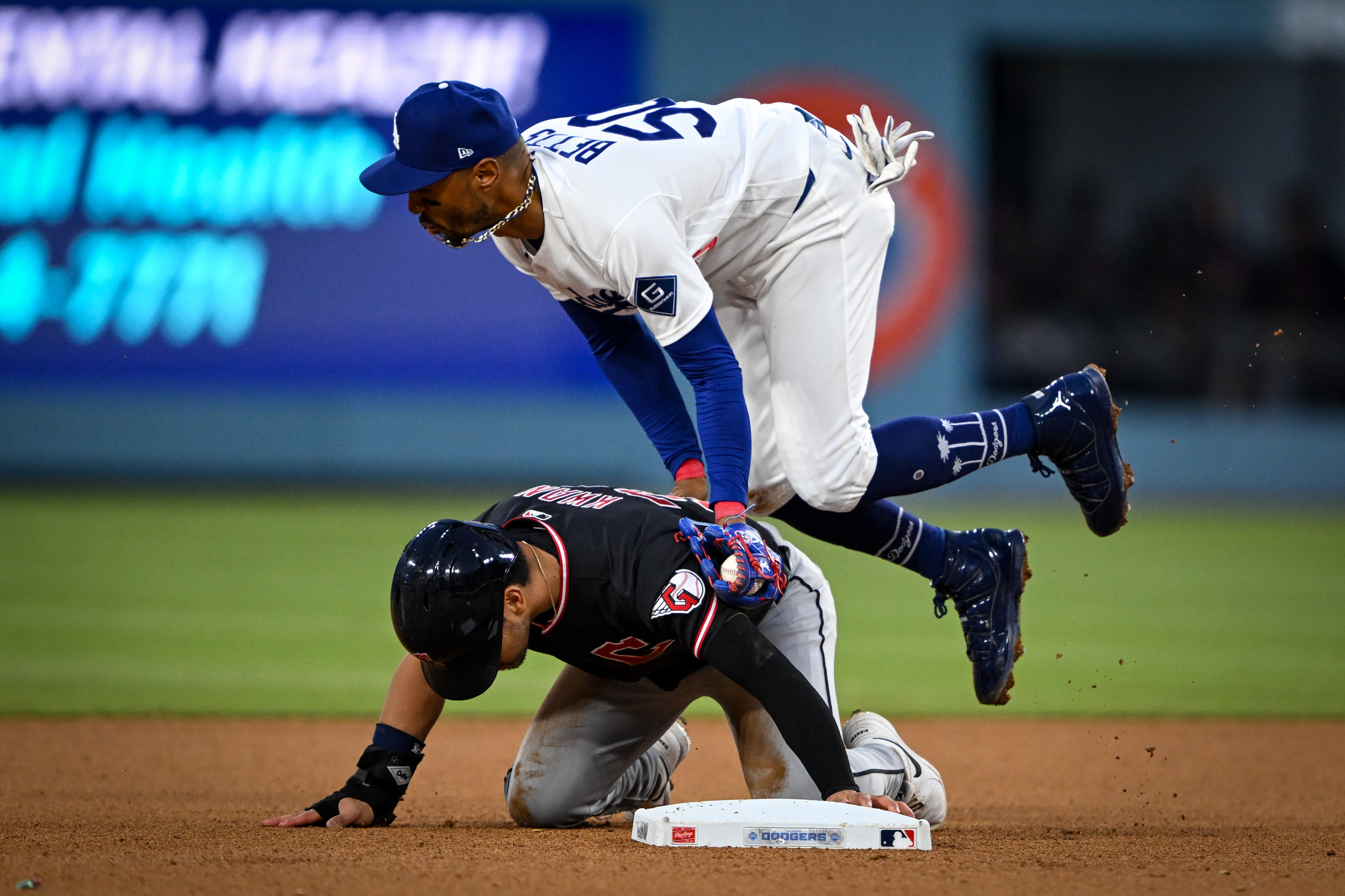 Dodgers shortstop Mookie Betts hurdles over the Cleveland Guardians’ Steven...