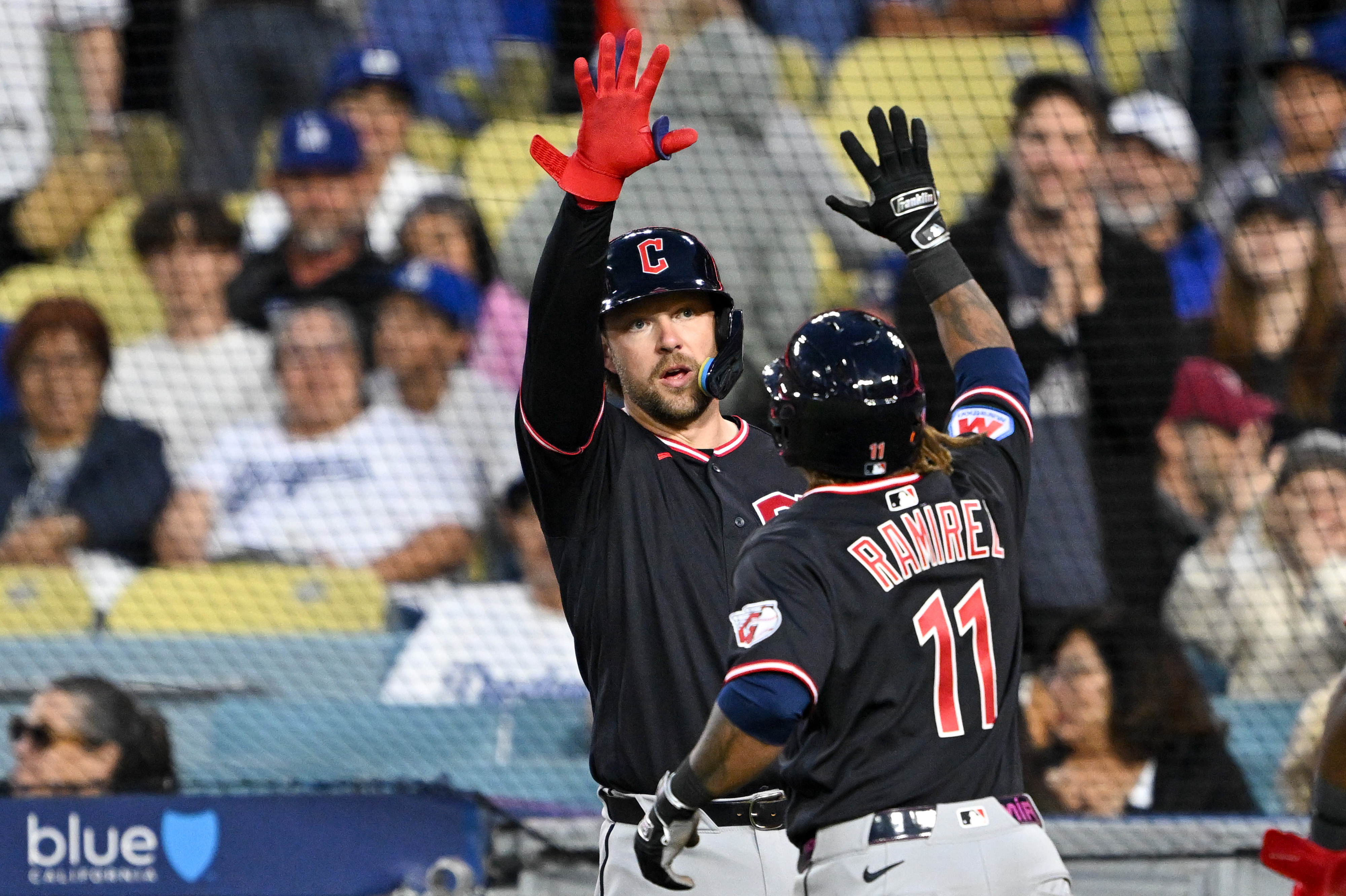 The Cleveland Guardians’ Jose Ramirez, right, celebrates after hitting a...
