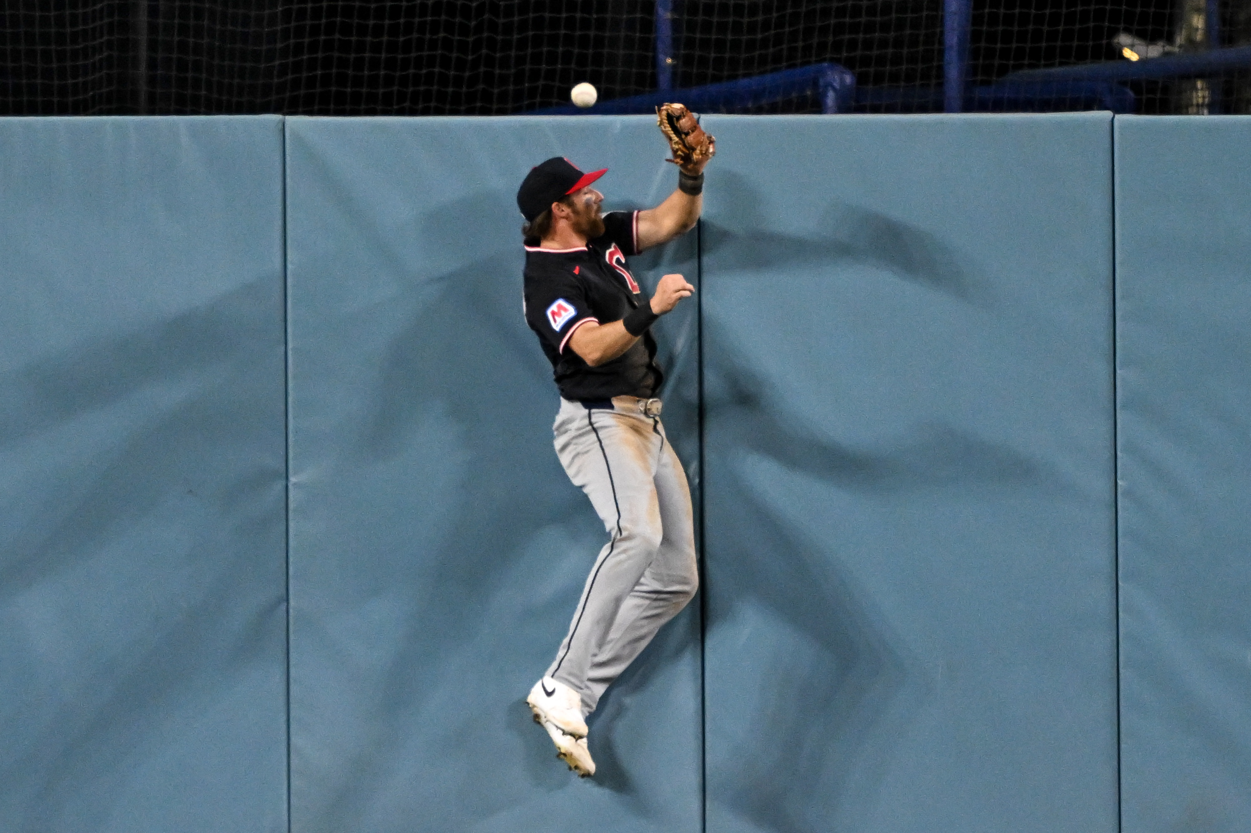 Cleveland Guardians center fielder Daniel Schneemann can’t reach a ball...