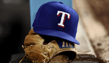 A detailed view of a Texas Rangers logo hat on top of a glove in the dugout against the Los Angeles Dodgers at Dodger Stadium on April 11, 2026 in Los Angeles, California. (Photo by Luke Hales/Getty Images)