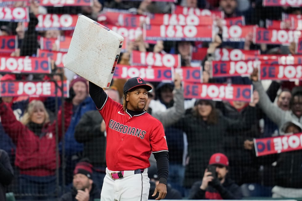 Cleveland Guardians third baseman José Ramírez holds third base after being presented with the...